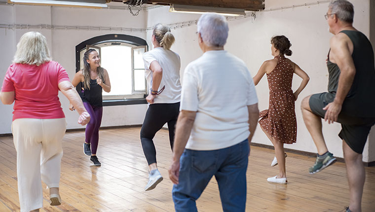 Gruppe mest ældre danser med ung instruktør